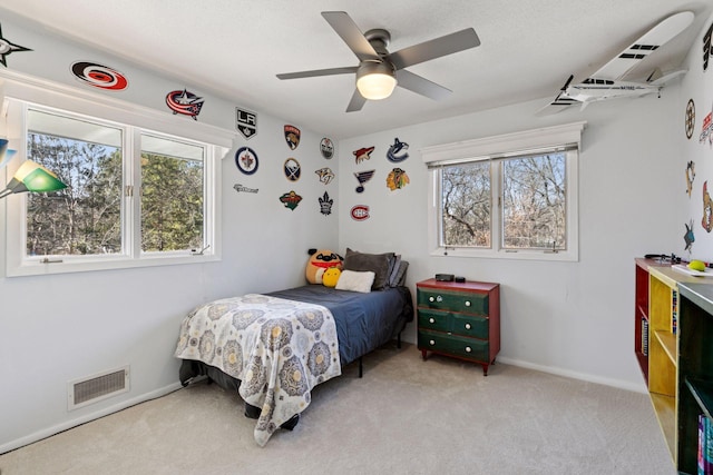 carpeted bedroom with baseboards, visible vents, and ceiling fan