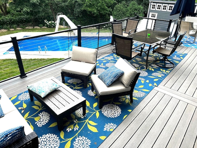 outdoor pool with a wooden deck and a water slide