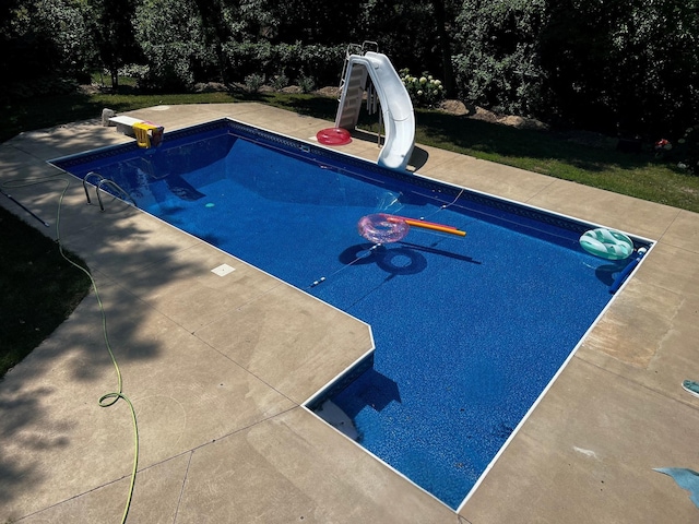 pool with a water slide and a diving board