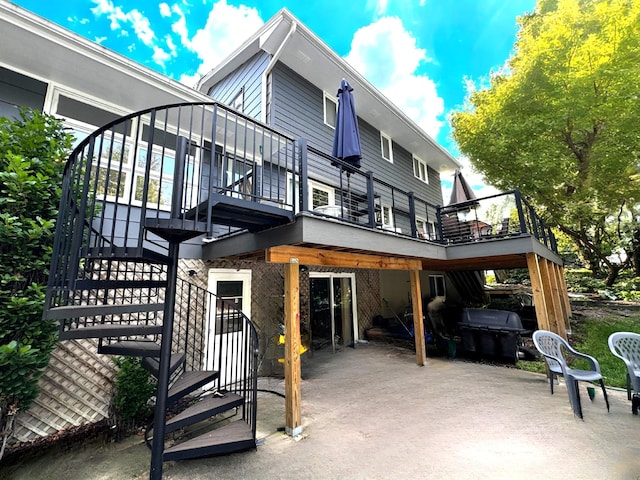 back of house featuring a patio area, a wooden deck, and stairs