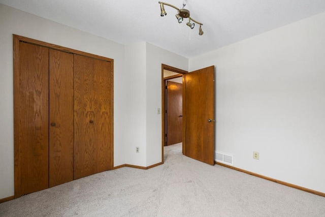 unfurnished bedroom with a closet, baseboards, visible vents, and carpet floors