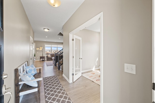 hall with wood finished floors, baseboards, and french doors