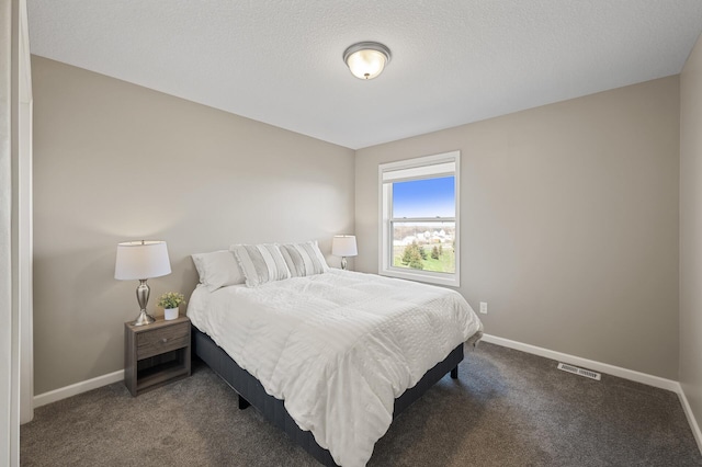 bedroom with carpet, baseboards, and a textured ceiling