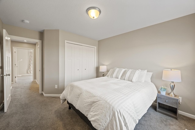 bedroom with carpet floors, baseboards, and a closet