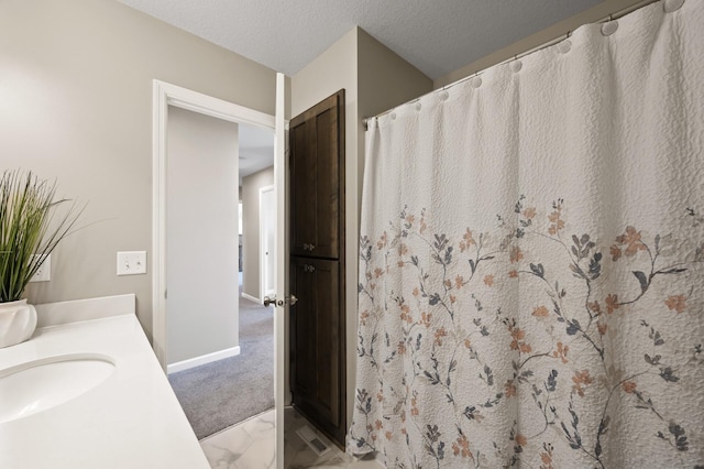 bathroom featuring marble finish floors, baseboards, vanity, and curtained shower