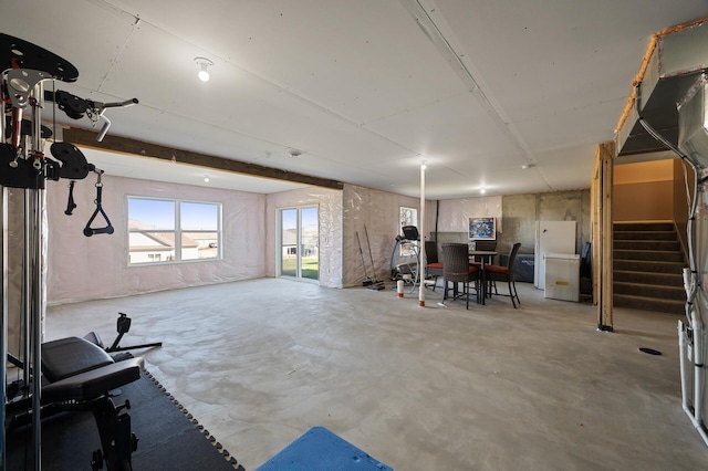basement featuring stairway and freestanding refrigerator
