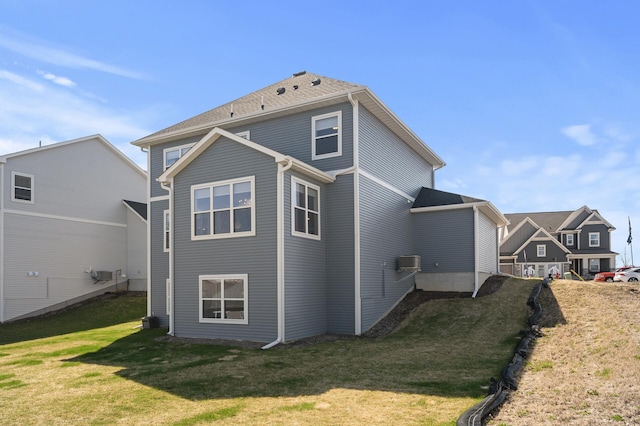 rear view of property with a lawn and a wall mounted AC