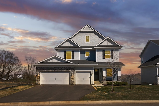 craftsman-style home featuring asphalt driveway, stone siding, an attached garage, a lawn, and board and batten siding