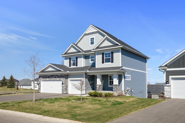 craftsman inspired home with driveway, a front lawn, stone siding, and covered porch