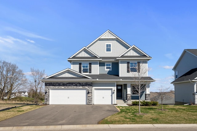 craftsman inspired home with driveway, stone siding, a front lawn, and board and batten siding