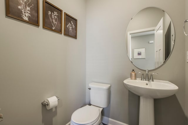 3459 109th Ln NE, Blaine, MN 55449 - half bathroom featuring toilet, baseboards, and a sink