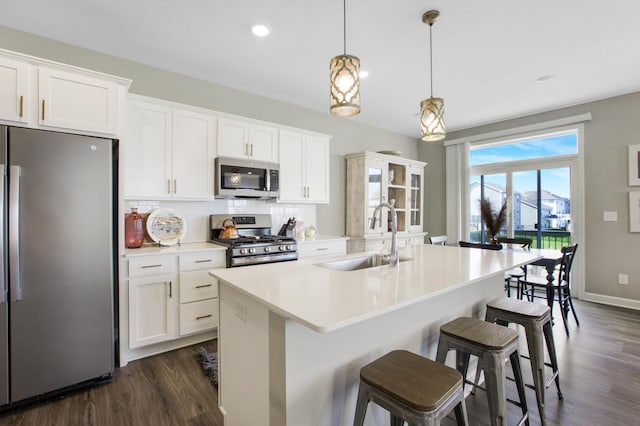 3459 109th Ln NE, Blaine, MN 55449 - kitchen featuring appliances with stainless steel finishes, a sink, dark wood-style floors, an island with sink, and recessed lighting