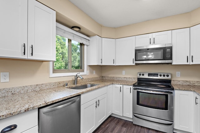 15320 90th St NE, Otsego, MN 55330 - kitchen featuring appliances with stainless steel finishes, white cabinets, dark wood-type flooring, and light stone counters