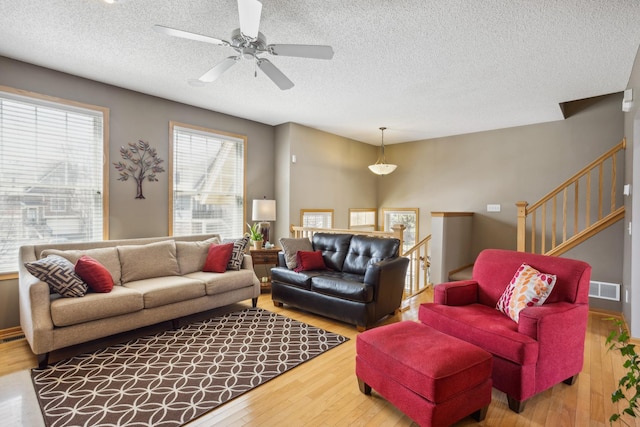 living room with visible vents, a textured ceiling, and wood finished floors