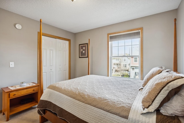 carpeted bedroom with a closet and a textured ceiling