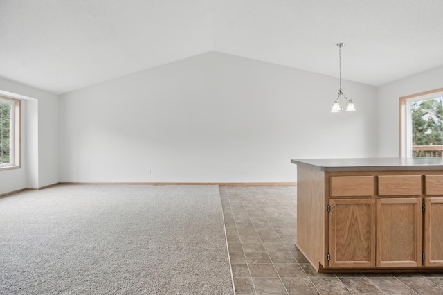 10310 Kaitlin Ave, Hanover, MN 55341 - kitchen featuring lofted ceiling, decorative light fixtures, brown cabinetry, open floor plan, and baseboards