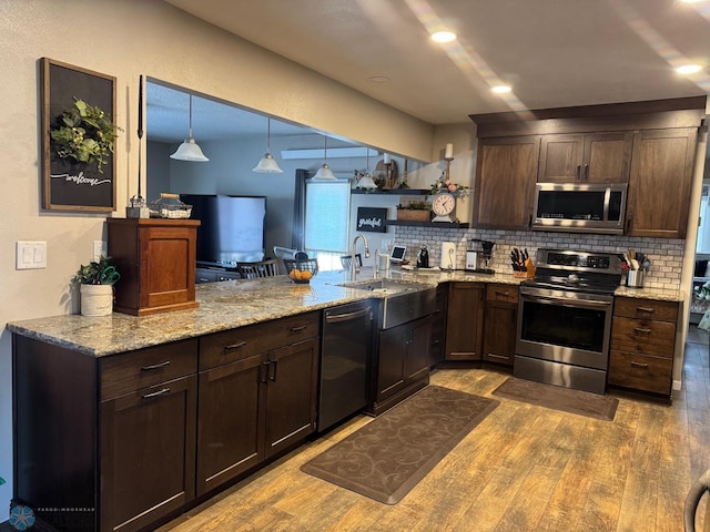 kitchen featuring dark brown cabinets, backsplash, appliances with stainless steel finishes, and dark wood-type flooring