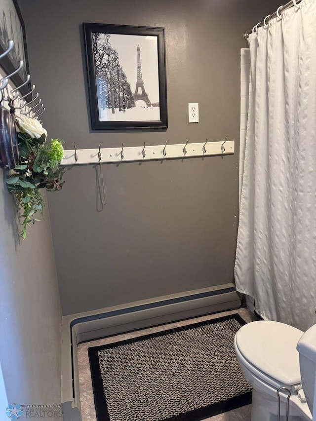 bathroom featuring toilet and a shower with curtain