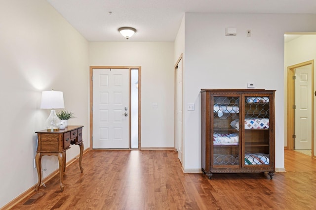 entryway with baseboards and wood finished floors