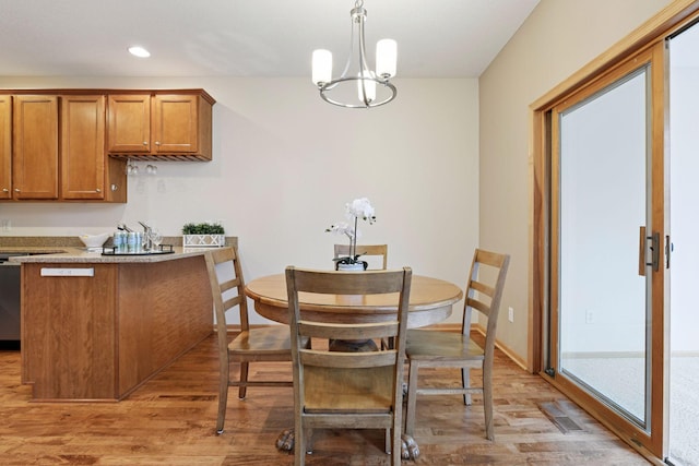 dining area with a notable chandelier, light wood-type flooring, baseboards, recessed lighting, and visible vents