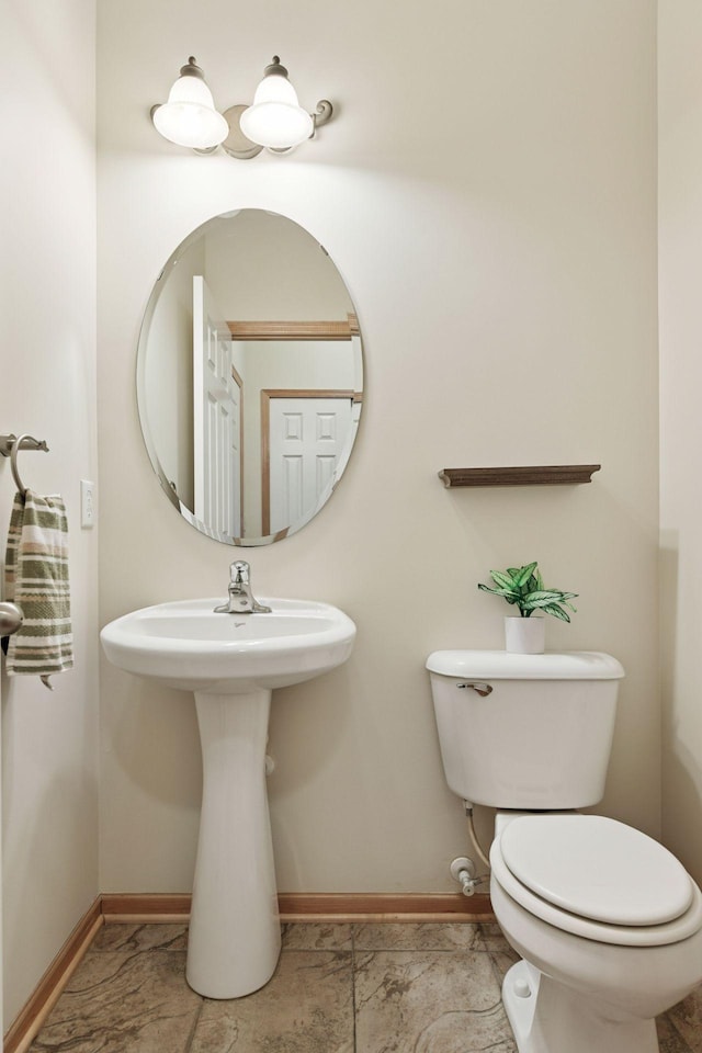 bathroom featuring toilet and baseboards