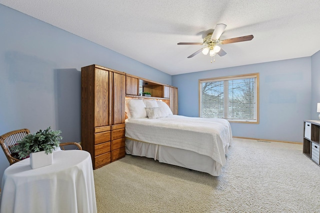bedroom with baseboards, light colored carpet, a textured ceiling, and ceiling fan
