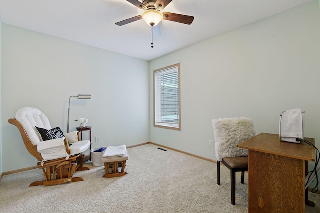 sitting room featuring baseboards, a ceiling fan, and carpet floors