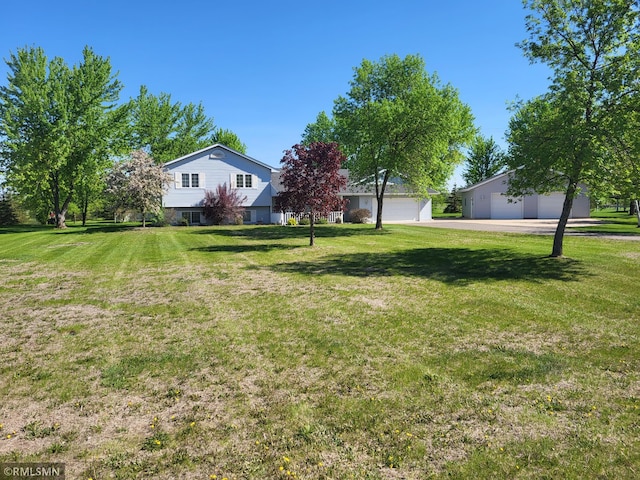 view of green lawn featuring a garage