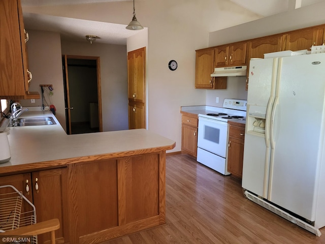 kitchen with white appliances, under cabinet range hood, brown cabinetry, a sink, and wood finished floors