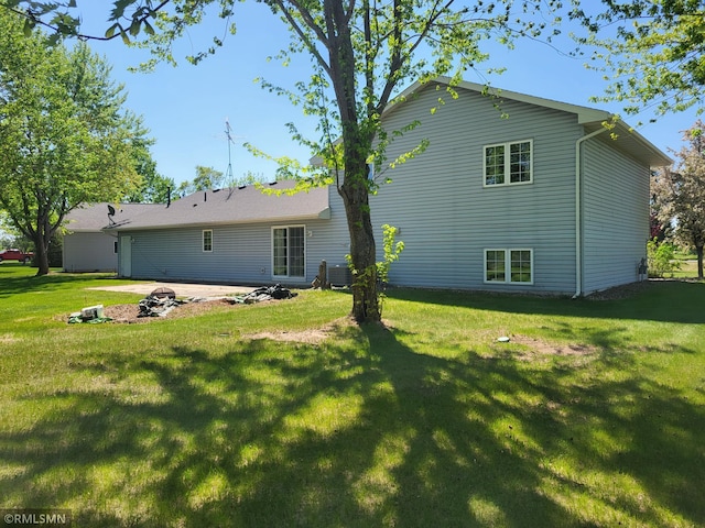back of property with a lawn and a patio area