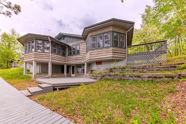 rear view of property with a deck and a sunroom