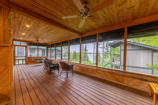 unfurnished sunroom featuring a ceiling fan and plenty of natural light