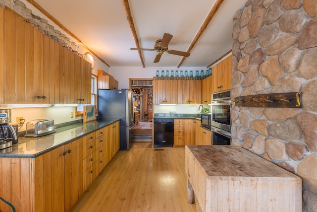 kitchen with dark countertops, light wood finished floors, a ceiling fan, and appliances with stainless steel finishes