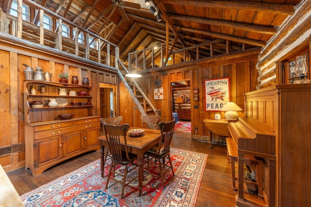 dining area featuring wooden ceiling, wooden walls, high vaulted ceiling, and dark wood-style flooring