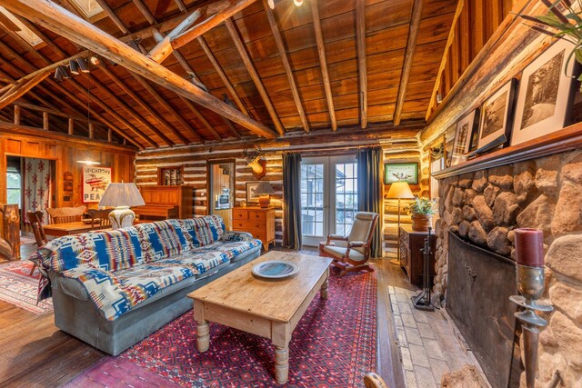 living area with rustic walls, french doors, beamed ceiling, high vaulted ceiling, and wood ceiling