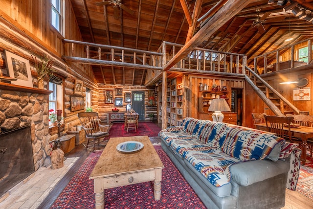 living area featuring hardwood / wood-style floors, high vaulted ceiling, ceiling fan, and log walls