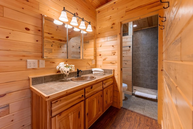 bathroom with wood walls, toilet, and wood finished floors
