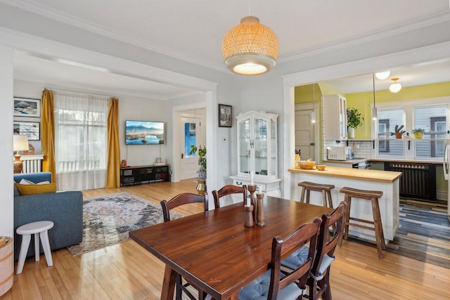 dining room with ornamental molding and hardwood / wood-style flooring