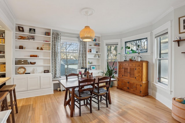 dining space featuring crown molding, built in features, plenty of natural light, and light wood-type flooring