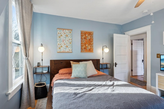 bedroom with wood finished floors, ceiling fan, and baseboards