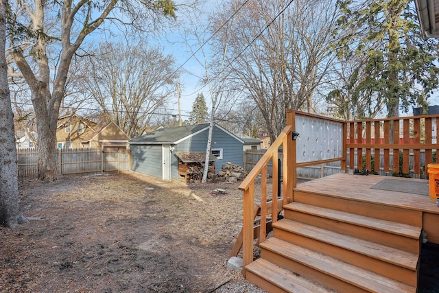 view of yard featuring an outbuilding, a fenced backyard, and a wooden deck