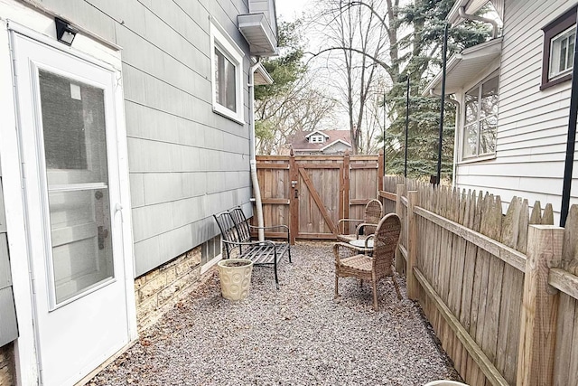 view of patio featuring fence and a gate