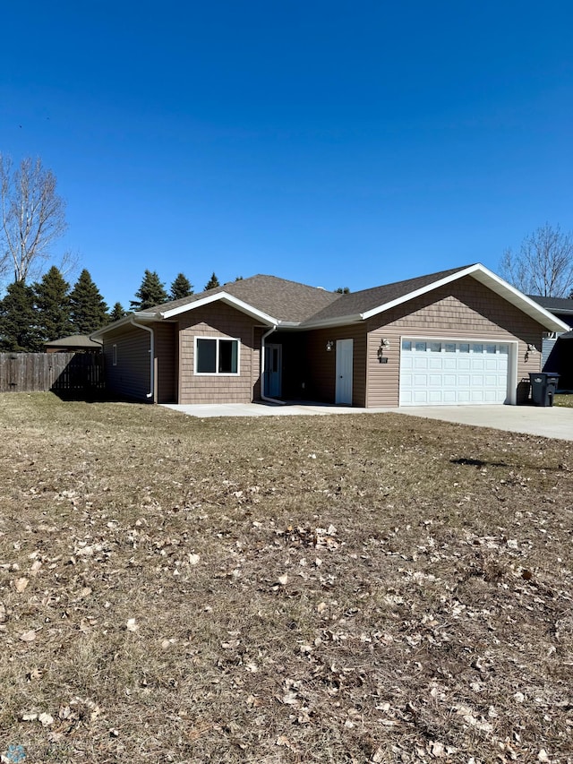 ranch-style home with driveway, fence, and a garage