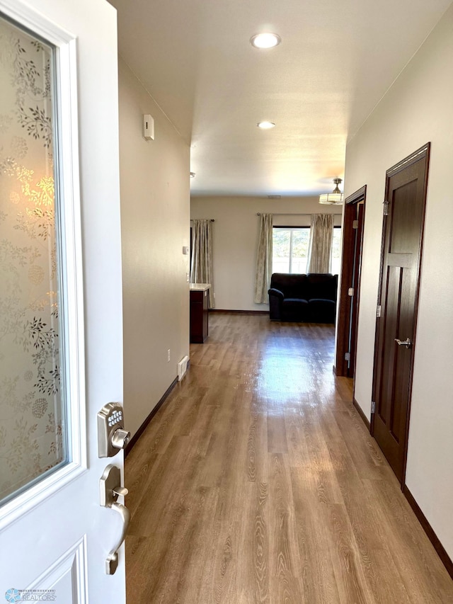 hall with recessed lighting, visible vents, baseboards, and wood finished floors