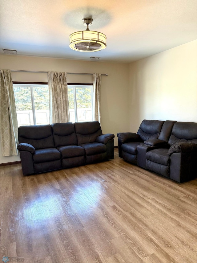living area with visible vents and wood finished floors