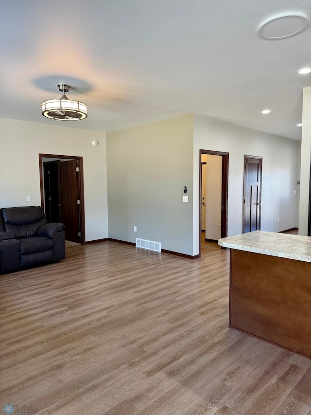 unfurnished living room featuring recessed lighting, visible vents, light wood-type flooring, and baseboards