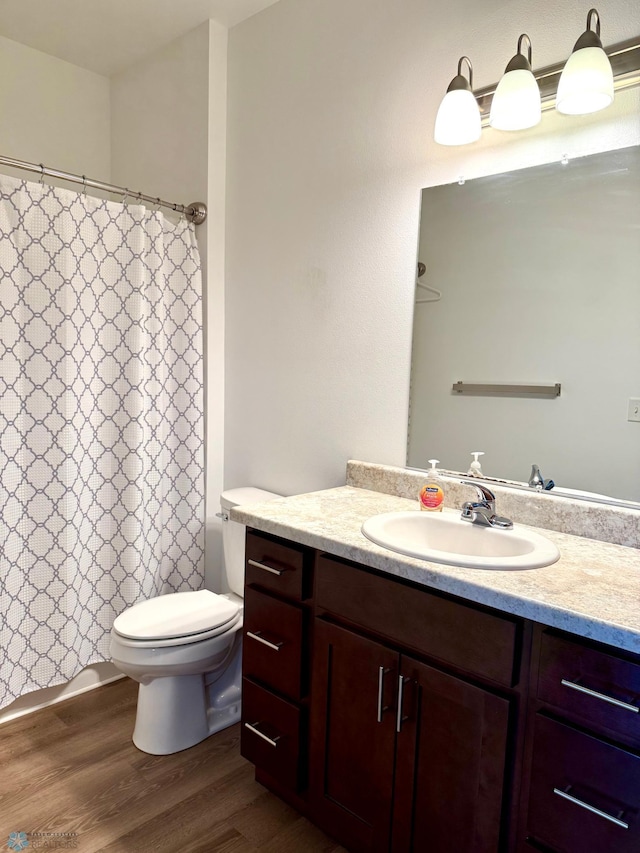 bathroom featuring vanity, a shower with curtain, toilet, and wood finished floors