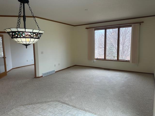 1017 Clausen Ave SW, Bemidji, MN 56601 - empty room featuring light carpet, baseboards, visible vents, and crown molding