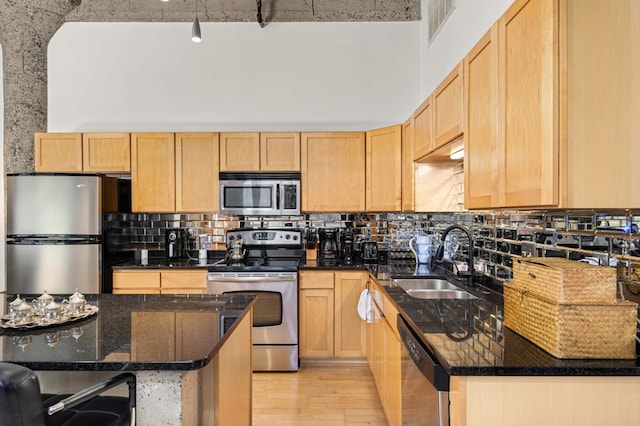 521 7th St Unit 311, Minneapolis, MN 55415 - kitchen featuring backsplash, light brown cabinetry, stainless steel appliances, and a sink