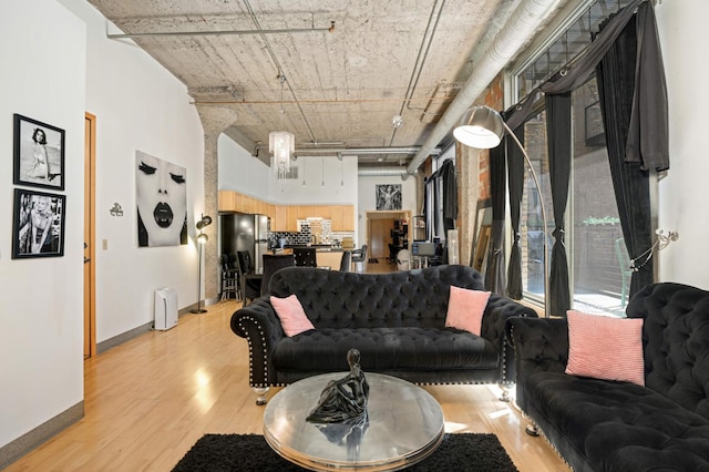 521 7th St Unit 311, Minneapolis, MN 55415 - living area with light wood-type flooring, a towering ceiling, and baseboards